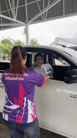 Woman exits pickup truck at Thai driving facility