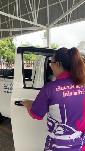 Woman exits pickup truck at Thai driving facility