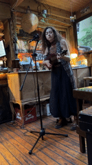 Woman performs ukulele set at Sofia cafe