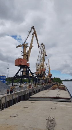 Workers and cargo barges active at Rybinsk river port