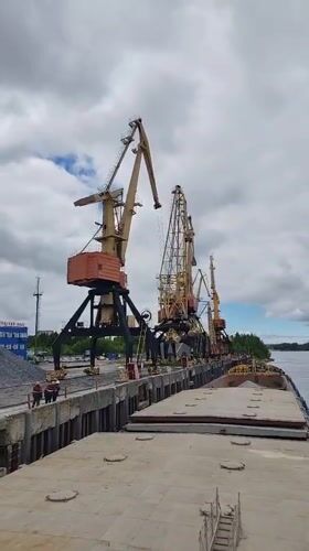Workers and cargo barges active at Rybinsk river port