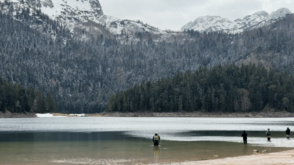 Person stands in calm lake waters in Montenegro