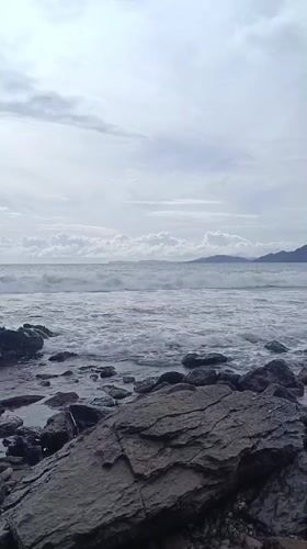 Rocky shoreline scene captured in Naga Umbang, Indonesia