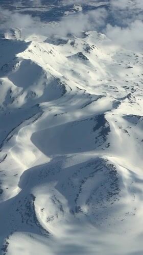 Passenger documents aerial mountain and landscape views during flight