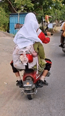 Red motorcycle duo with pink backpack cruising through Lhokseumawe