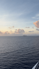 Cruise ship sails Berry Islands waters under colorful skies