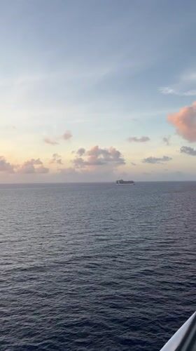 Cruise ship sails Berry Islands waters under colorful skies