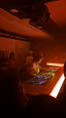 Female DJ performs behind number-7 shaped console at Paris nightclub