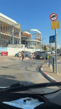 Children serve as crossing guards in Tel Mond street