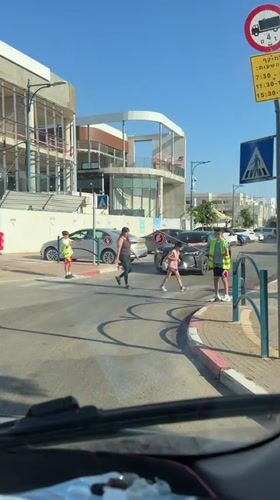 Children serve as crossing guards in Tel Mond street