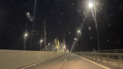 Night drive across illuminated bridge in Calafat, Romania
