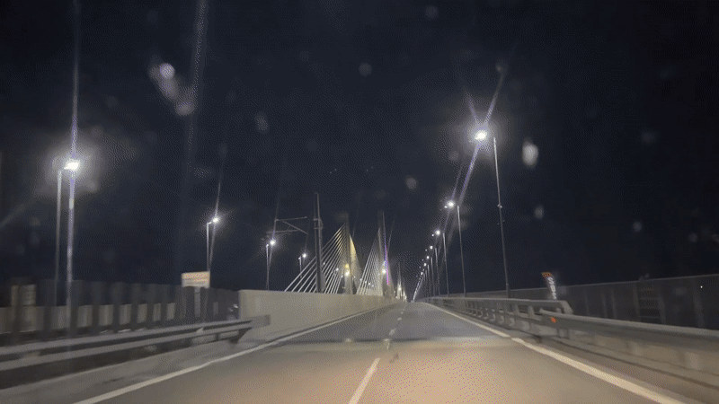 Night drive across illuminated bridge in Calafat, Romania