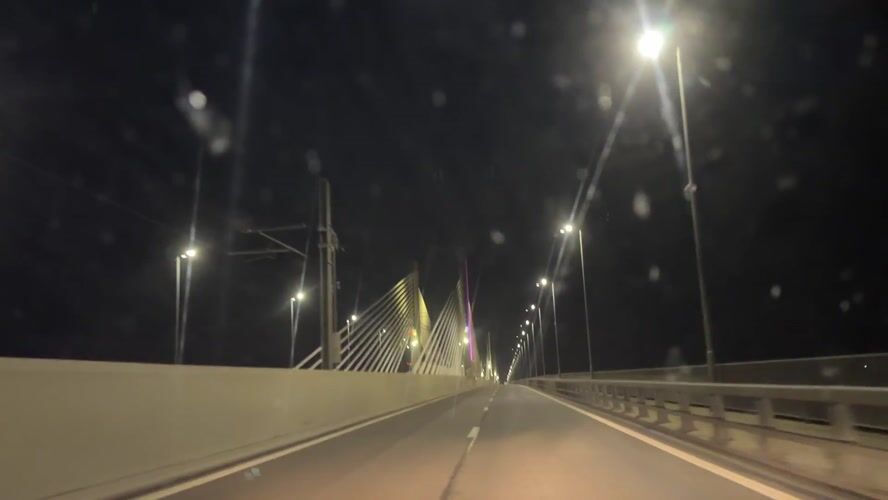 Night drive across illuminated bridge in Calafat, Romania