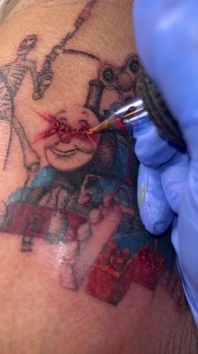 Tattoo artist works with red ink in Buenos Aires