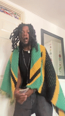 Man in Jamaican-colored shawl observed indoors in London