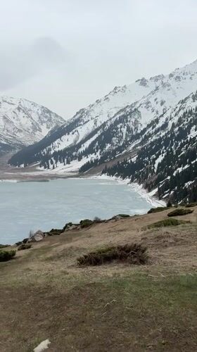 Woman documents mountain lake scenery near Almaty, Kazakhstan