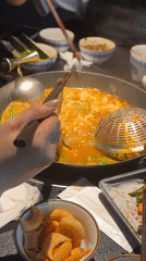 Woman enjoys hot pot meal in Chongqing restaurant