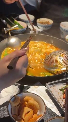 Woman enjoys hot pot meal in Chongqing restaurant