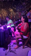 Nighttime outdoor concert featuring three women performers in Búzios