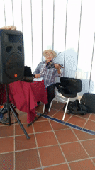Elderly violinist performs sunset concert on Venezuelan island terrace