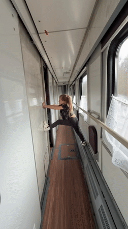 Girl performs split in Russian train corridor