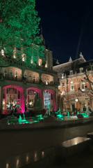 Green-lit fountain observed in nighttime Amsterdam scene