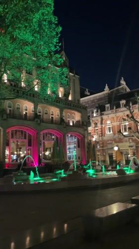 Green-lit fountain observed in nighttime Amsterdam scene