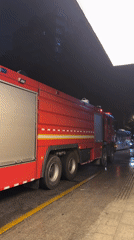 Cyclist passes emergency fire truck on Tianhe District road