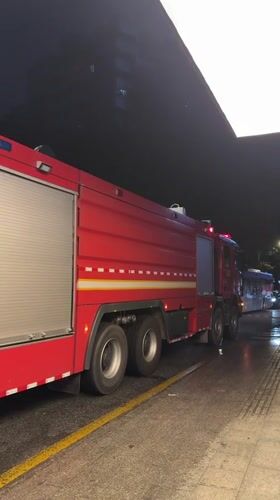 Cyclist passes emergency fire truck on Tianhe District road