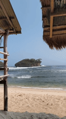 Morning beach scene at Watu Karung with waves and a rocky island