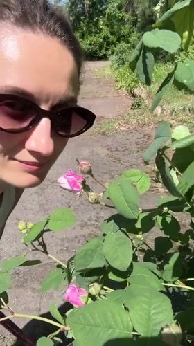 Woman enjoys spring roses in Kryvyi Rih garden