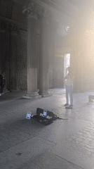 Violinist busking under a Parisian archway, late afternoon