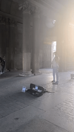 Violinist busking under a Parisian archway, late afternoon