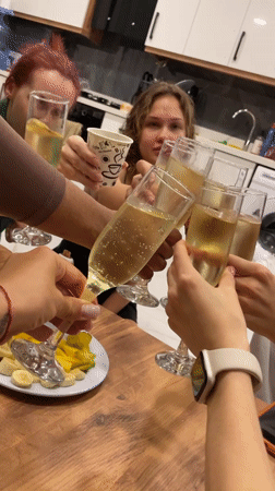 Group celebrates with champagne toast in Kuşadası kitchen