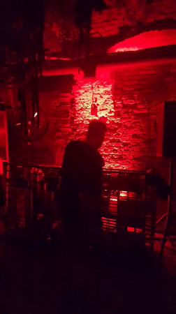 DJ set and crowd in a red-lit club venue