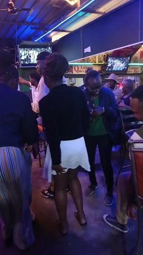 Evening social gathering at Nairobi bar with neon lighting