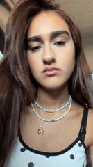Close-up portrait featuring a polka-dot top and layered necklaces