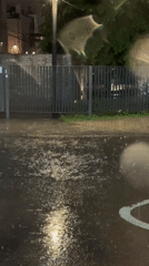 Evening rain creates streetlight reflections on Moscow pavement