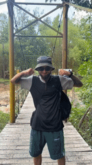 Tourist films phone footage while crossing suspension bridge in Vietnam