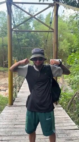 Tourist films phone footage while crossing suspension bridge in Vietnam
