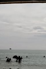 Beach vendors and swimmers active in Lhokseumawe despite overcast weather