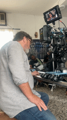 Film crew member observes camera setup on movie set