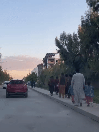 Man sits on wooden cart in Kandahar street scene