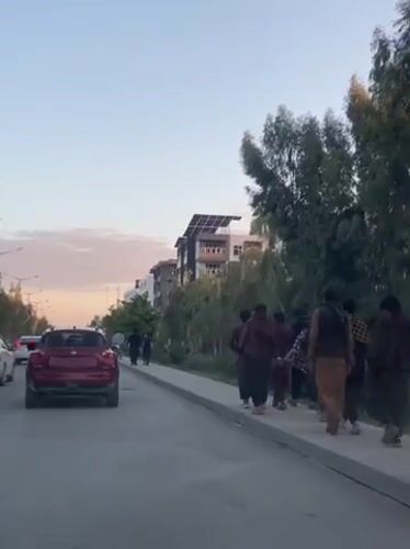Man sits on wooden cart in Kandahar street scene
