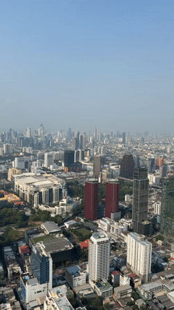 Aerial footage captures Bangkok cityscape under hazy sunny skies