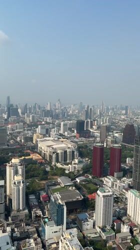 Aerial footage captures Bangkok cityscape under hazy sunny skies