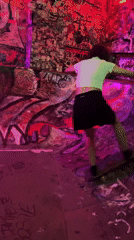 Skateboarder rides bowl at graffiti-covered concrete skatepark
