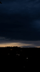 Storm clouds gather over urban neighborhood at dusk