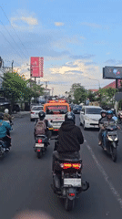 Scooter rider documents busy traffic in Denpasar, Bali