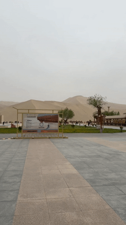 Tourists explore Dunhuang desert dunes from visitor plaza